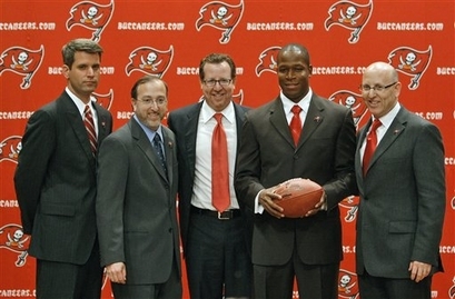 Raheem  Morris  (second  from the  right )  and   Bucs'  General  Manager   Mark  Dominik  (left) are  seen  here  with  members  of  the  Glazer   family  , owners  of   both  the   Tampa  Bay  Buccaneers  as  well   English  Premier  League  soccer club  Manchester United  .     photo  appears courtesy  of  Getty Images  / Paul  Mason  ..............