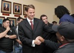 Los Angeles -January 13th 2010. New head coach of the USC Trojans Lane Kiffin shakes a hand as he makes his way to his press conference at Heritage Hall in Los Angeles, California. photo appears courtesy of Getty Images/ Harry How .................