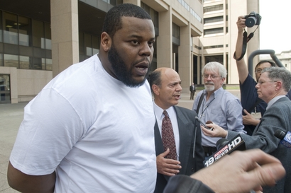 Cleveland Browns nose tackle Shaun Rogers and his lawyer Patrick D'Angelo, center, talk to reporters after leaving Cleveland Police Headquarters where Rogers was charged with one felony count of carrying a concealed weapon on Friday, April 2, 2010, in Cleveland, Ohio. Rogers was arrested at Cleveland Hopkins International airport on Thursday after he tried to take a loaded handgun through airport security. photo appears courtesy of Associated Press/ Jason Miller .....
