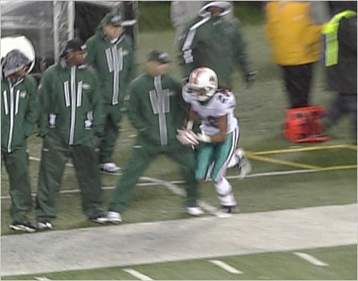 The Miami Dolphins' Nolan Carroll in full stride down the sidelines in an NFL game played against the New York Jets played at New Meadowlands Stadium , East Rutherford , New Jersey. Alosi is seen here tripping the player who suffered no seriously sustainable injuries . For Carroll his team would have the last laugh as they defeated the Jets 10-6 in the divisional match-up of these AFC East rivals . courtesy of AP Photo/ Mark Gresham .........